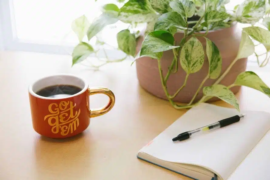 Desk top with "Go Get Em" Coffee Mug and Notebook