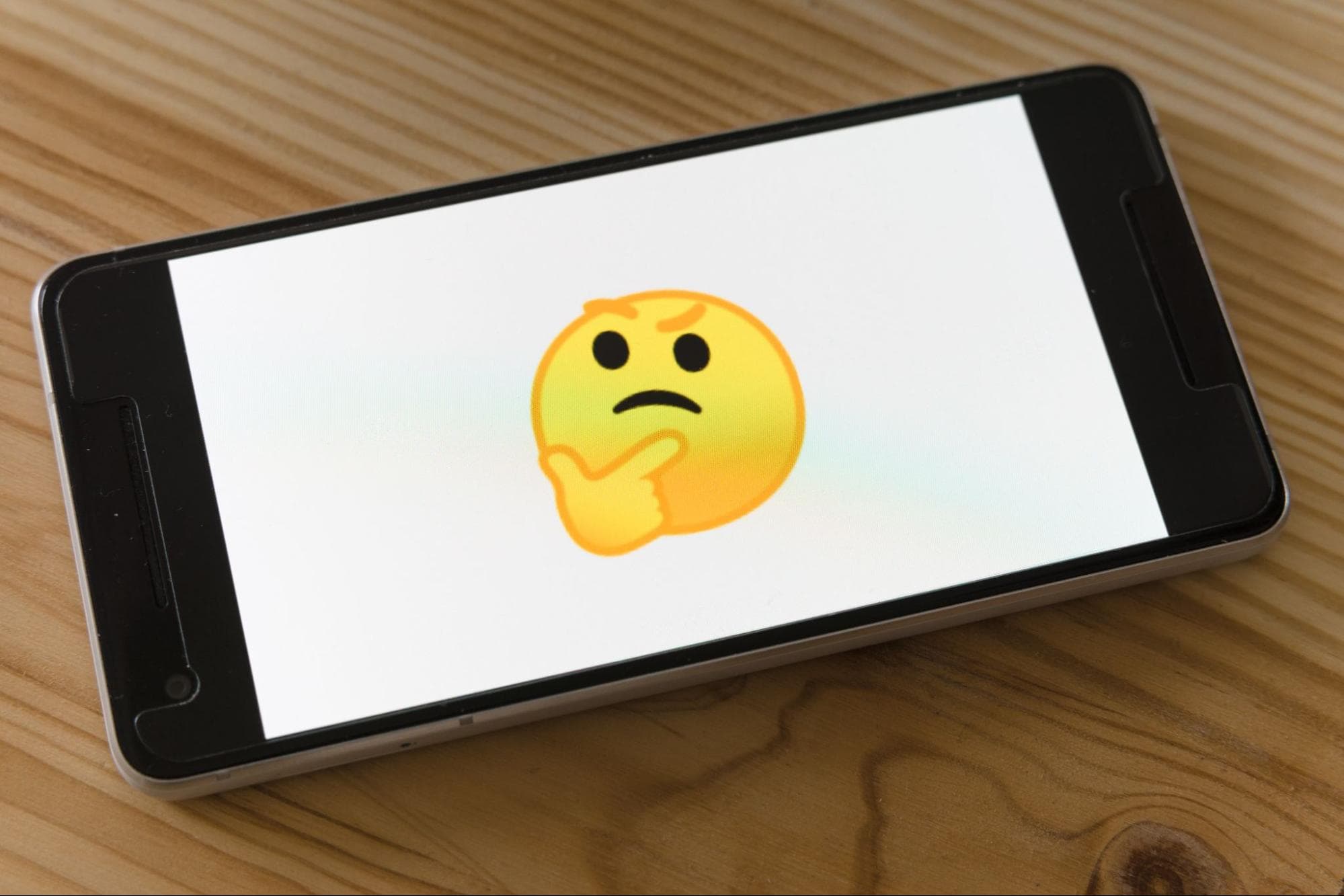 Thinking emoji face on mobile phone