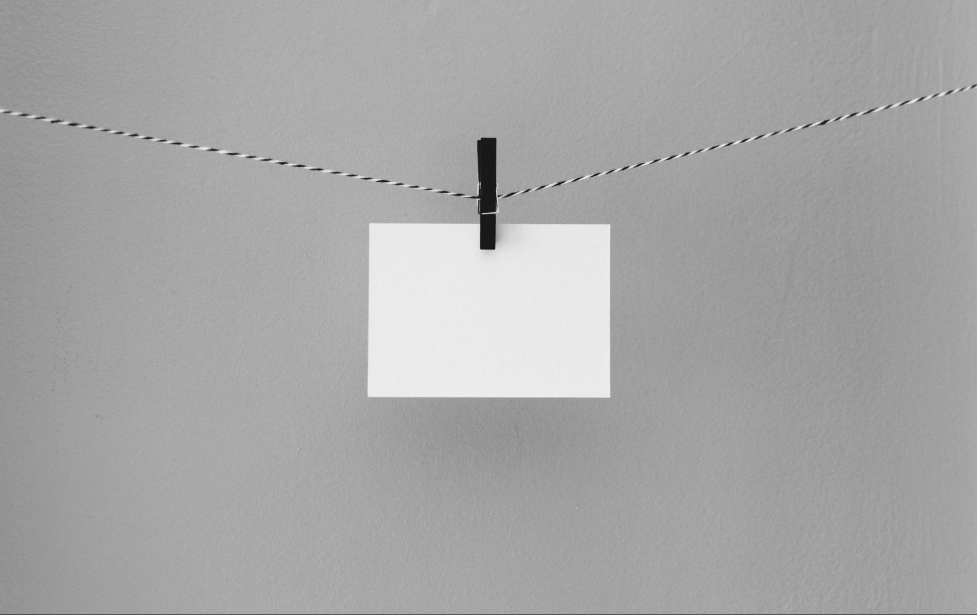 White card hanging from horizontal string