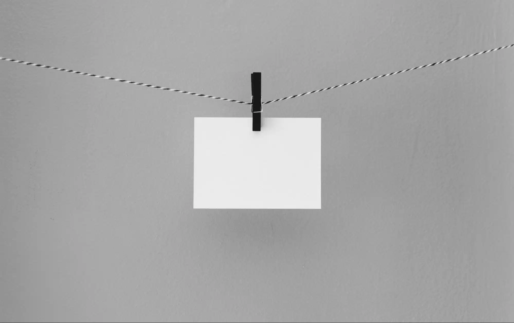 White card hanging from horizontal string