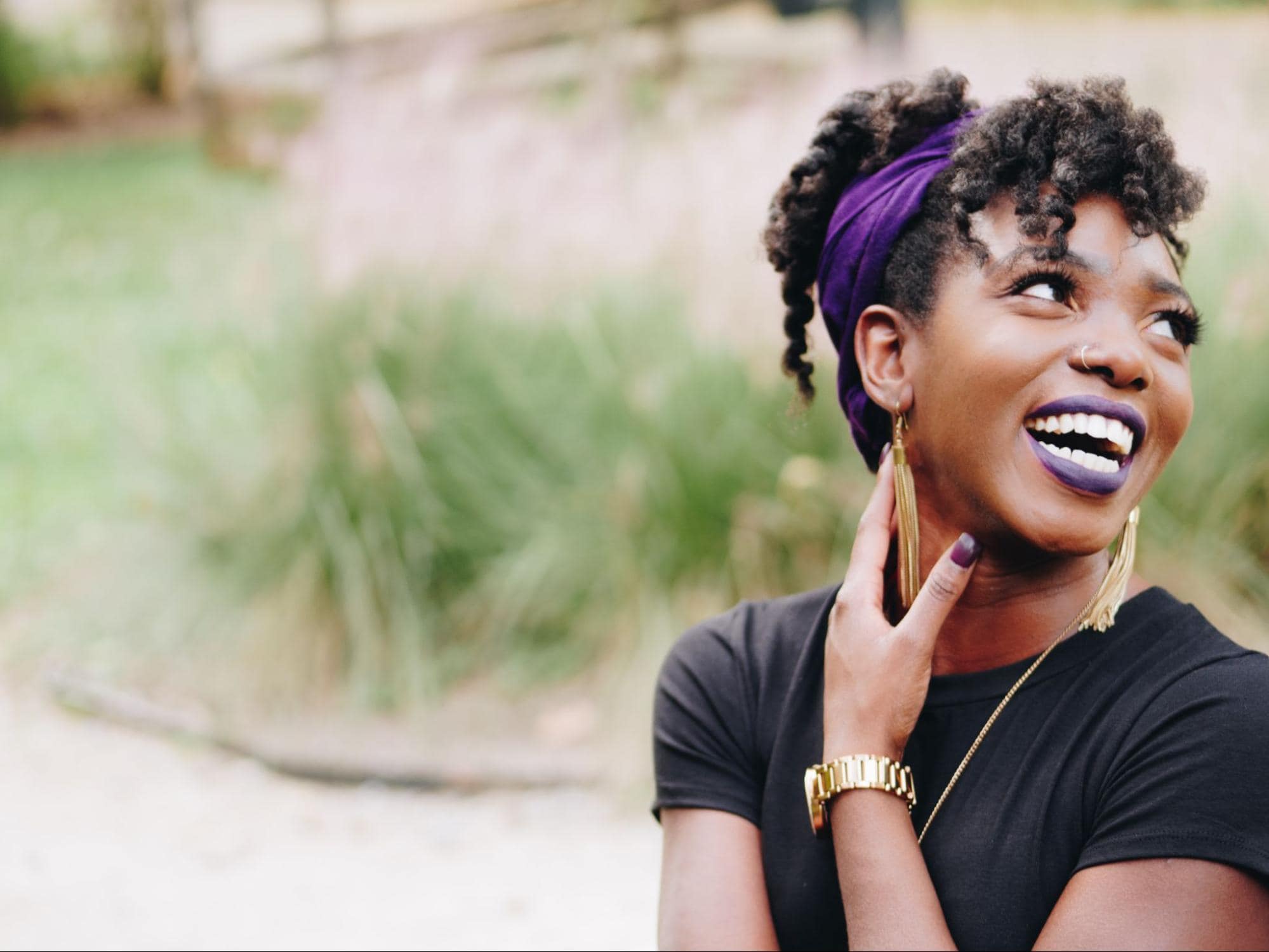 Black woman laughing wearing purple lipstick