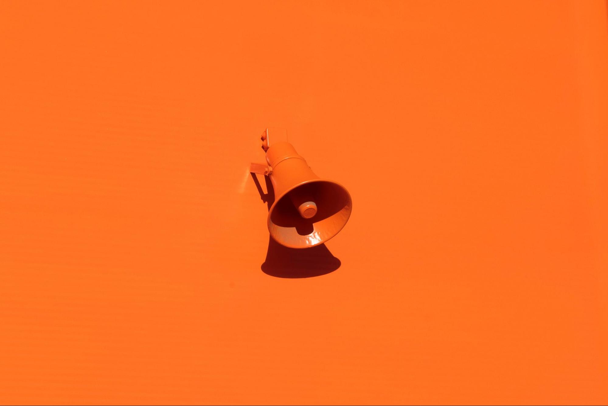 Bright orange background and megaphone