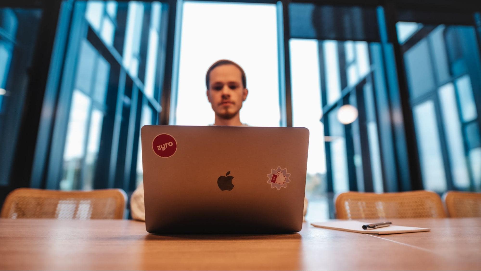 Man working at laptop with Zyro logo sticker